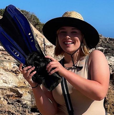 girl holding flippers found on beach