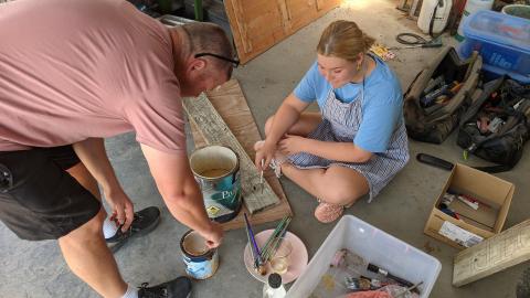 dad setting teen girl up for painting the sign