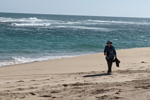 woman looking for trash on the beach