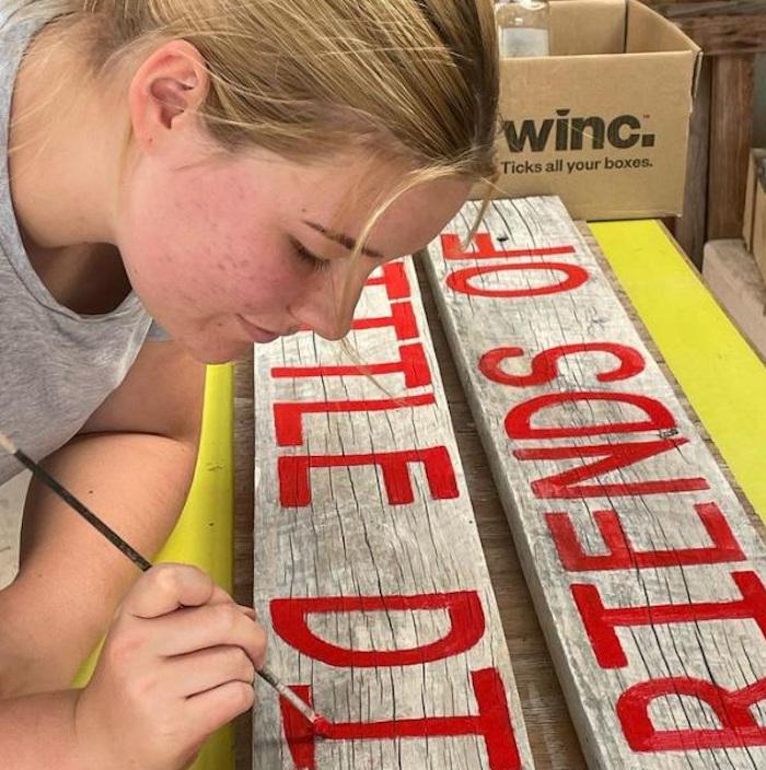 Libby finishing painting sign